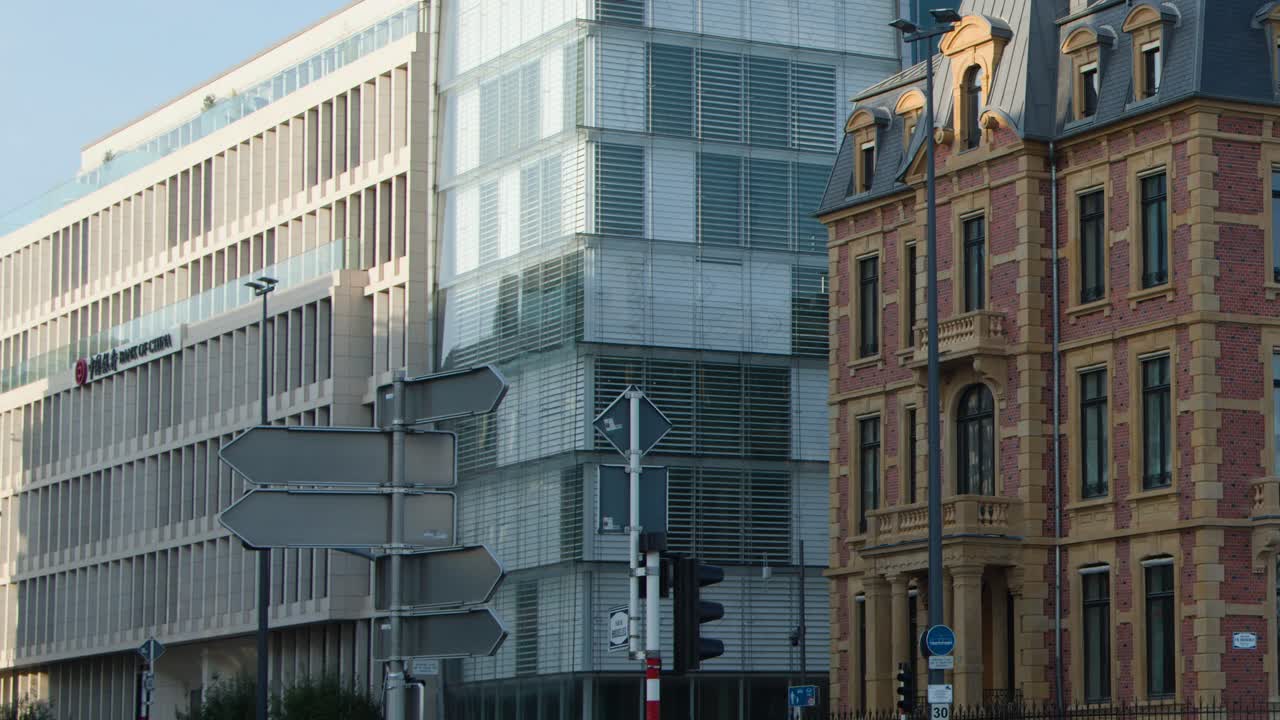 Modern tram glides past historic and contemporary architecture in bright midday urban Luxembourg setting