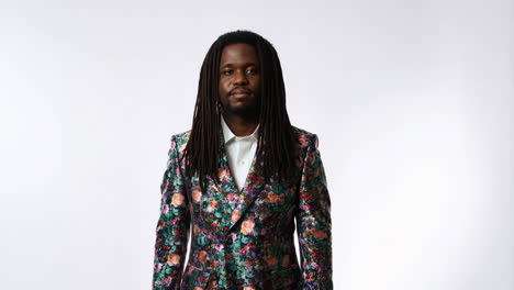 portrait of a man with dreadlocks wearing a floral blazer