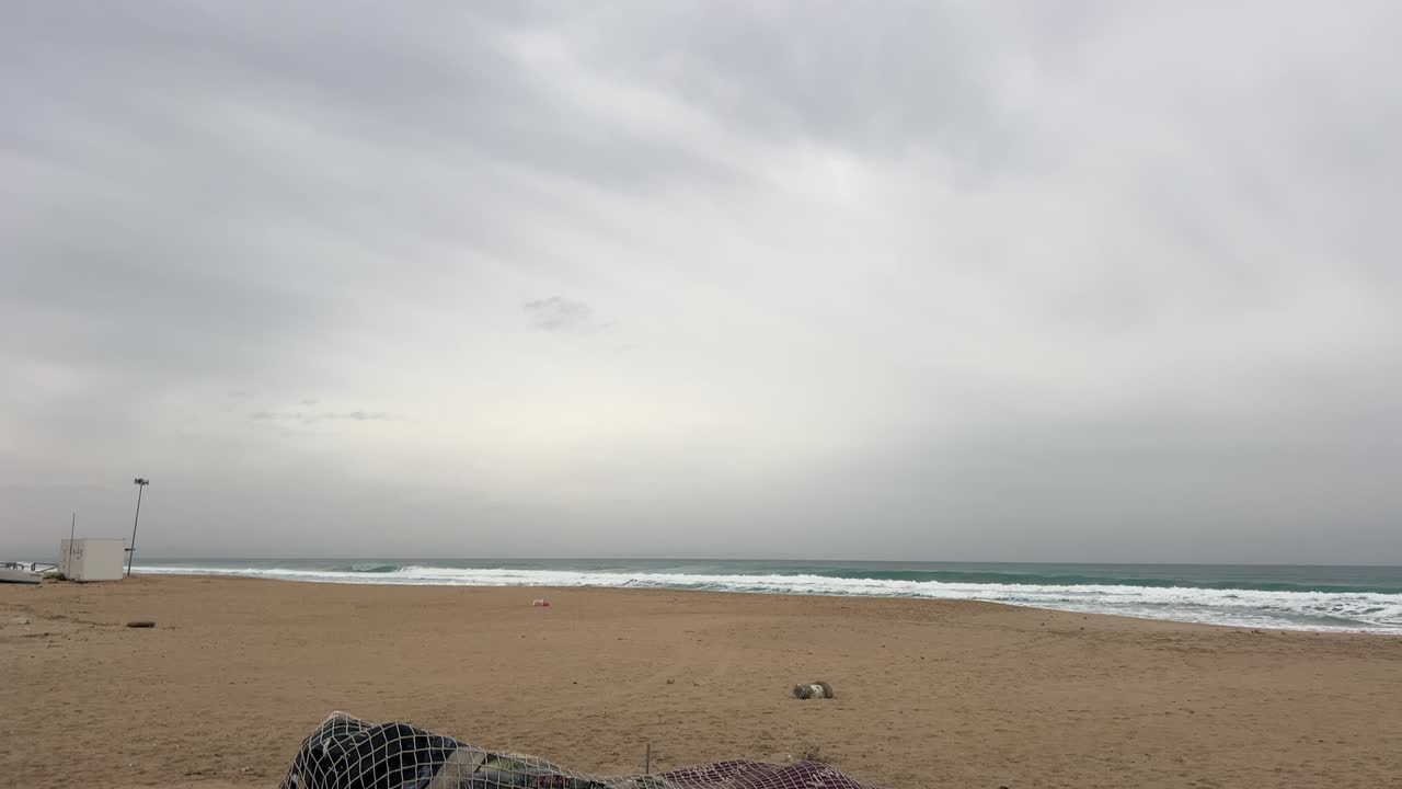 Dog Playing Around a Covered Boat on a Cloudy Beach