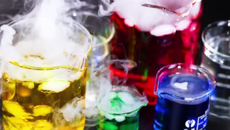 vibrant liquids reacting with smoke in beakers