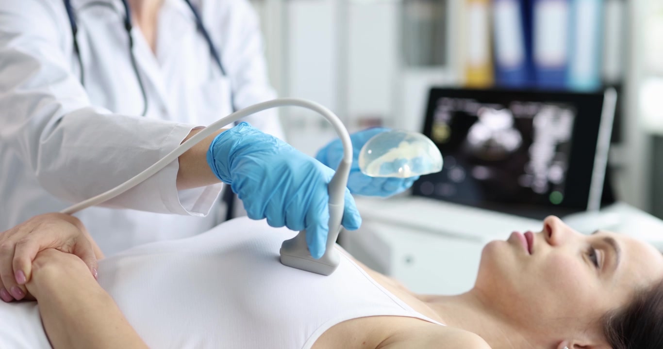 Medico esamina gli impianti di una donna con ultrasuoni in clinica
