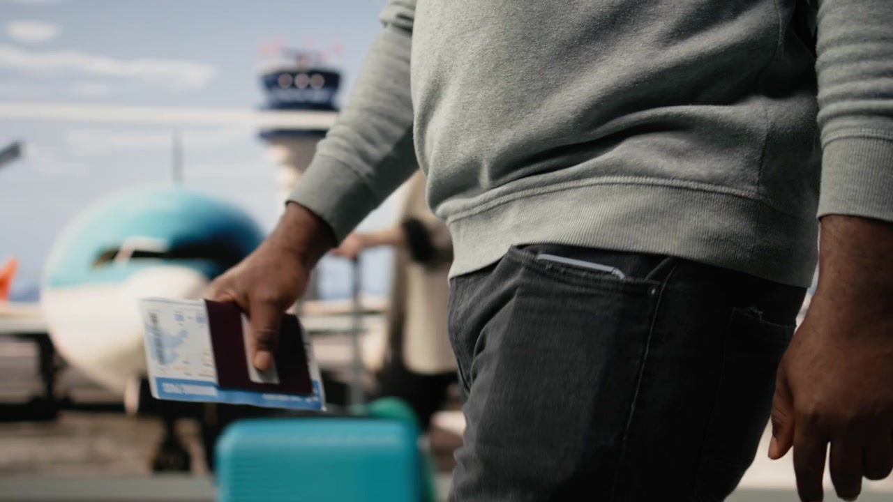 Close up of travel documents held by tourist walking in airport