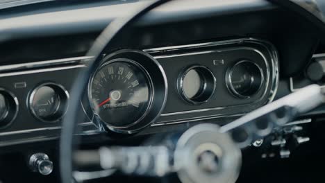 close-up of a vintage car dashboard with classic gauges and steering wheel