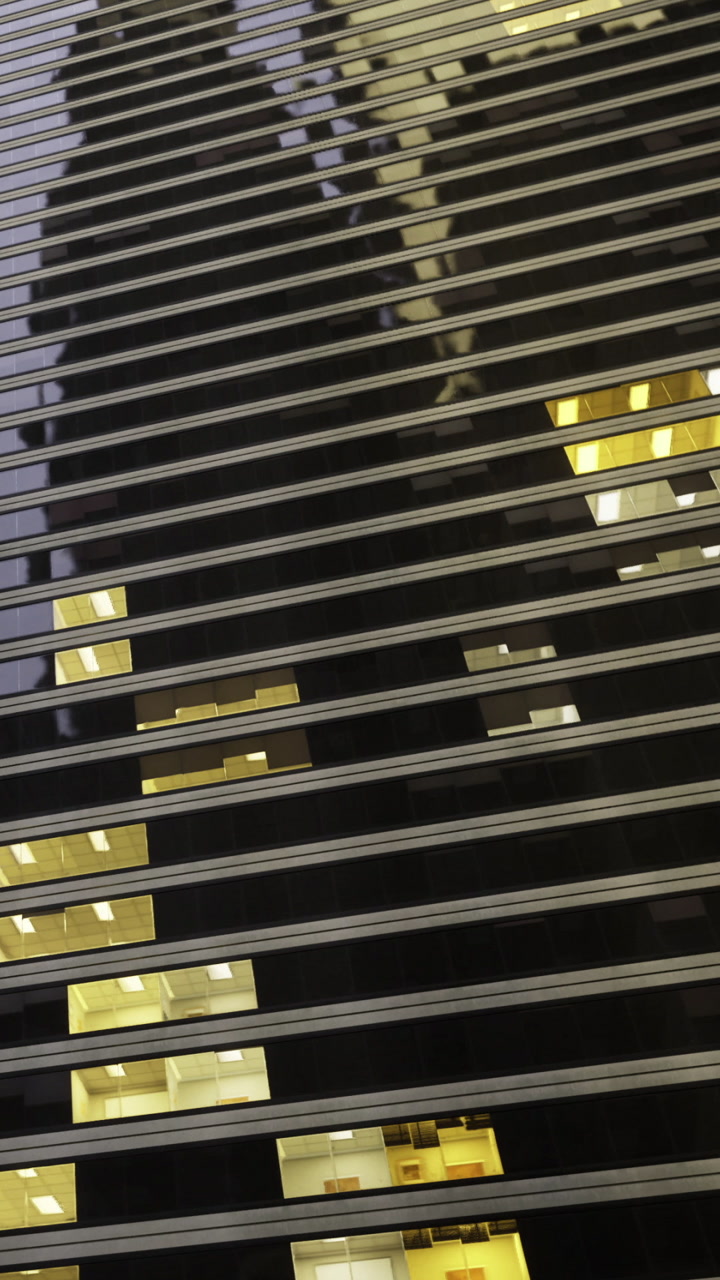 Windows reflect light in urban setting during evening hours