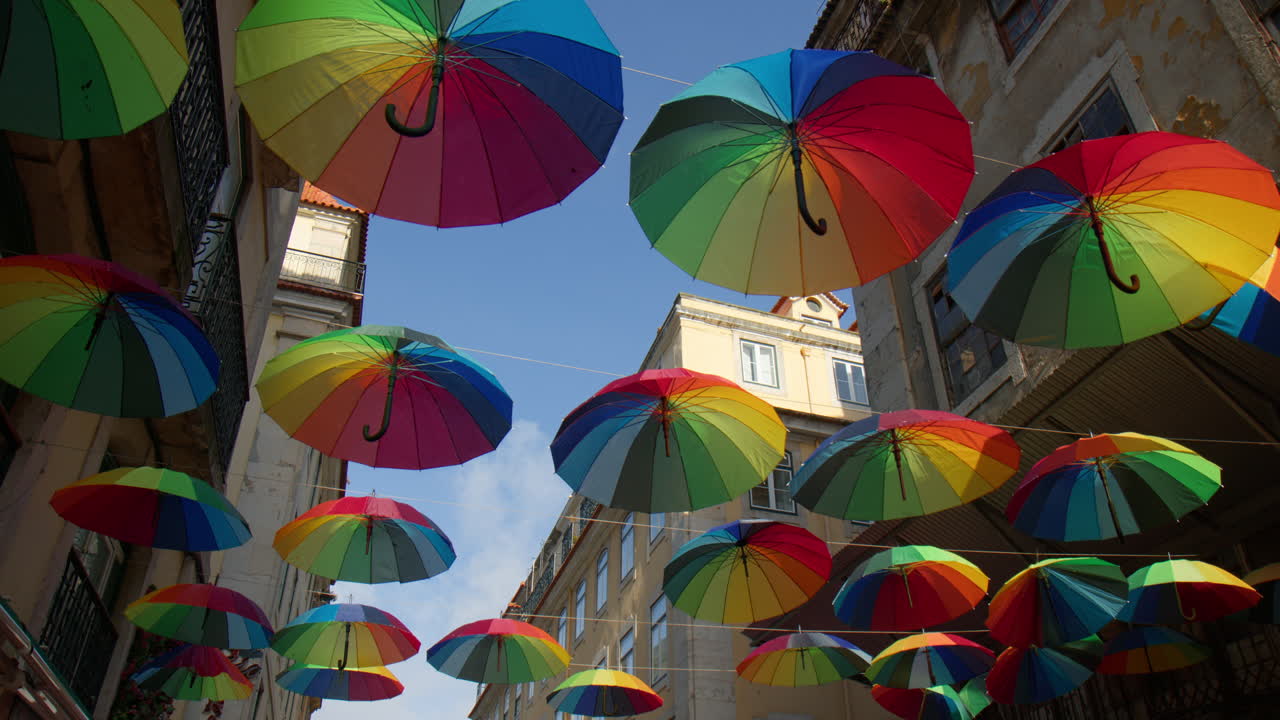 paraguas de colores arco iris colgando en la calle rosa en lisboa, portugal