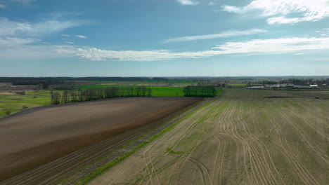 aerial view of a brown and green field with a road dividing the two