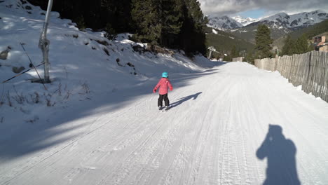 little girl having fun learning to ski on french andorra winter resort slope