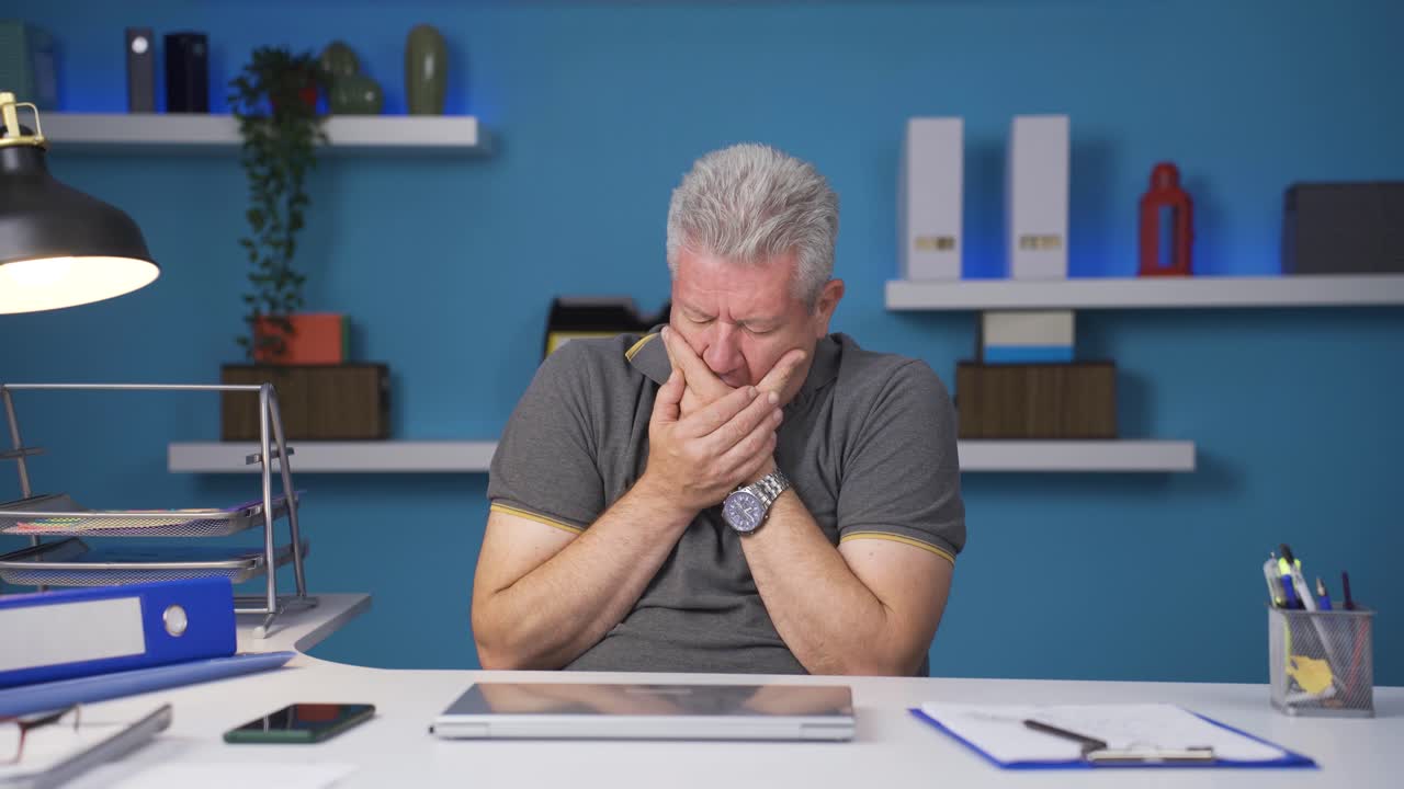 Home office worker man teeth aches and pains.