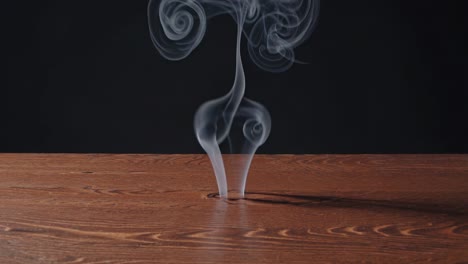 Smoke rising from a hole in a wooden table
