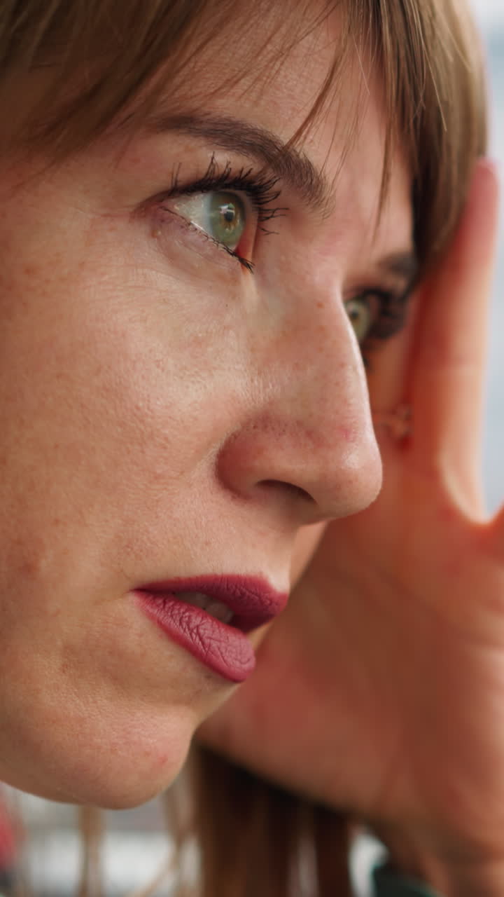 una mujer cansada en un coche presiona la mano contra el templo esperando la oportunidad de moverse. una conductora en un atasco de tráfico no puede llegar a casa a tiempo en un primer plano de fondo borroso