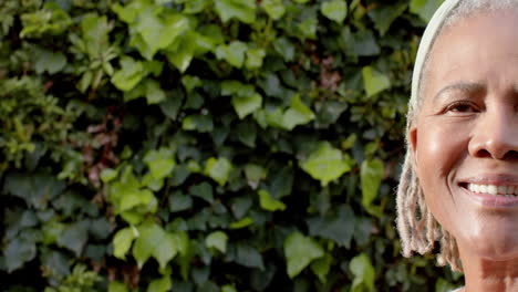 Half-portrait-of-happy-senior-african-american-woman-smiling-in-garden,-copy-space,-slow-motion