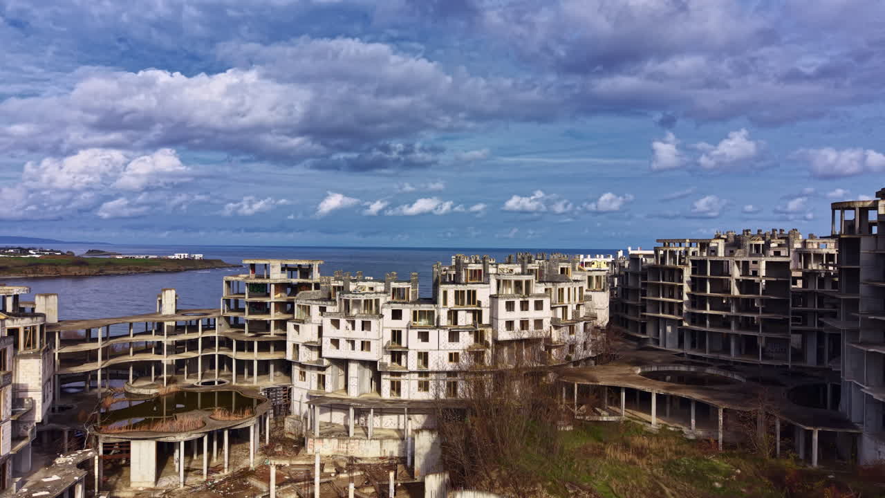 Beautiful decay in a forgotten coastal city reveals nature's reclaiming touch amidst hauntingly silent structures under a dramatic sky