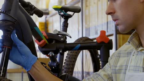 Man-repairing-bicycle-in-workshop-4k