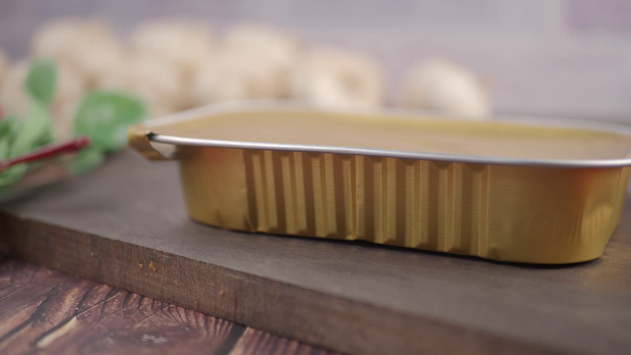 Patê em um Recipiente Dourado de Alumínio sobre uma Tábua de Madeira.