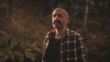 man by river in forest enjoys golden sunlight and nature. he feels calm and peaceful. soothing and warm nature clip