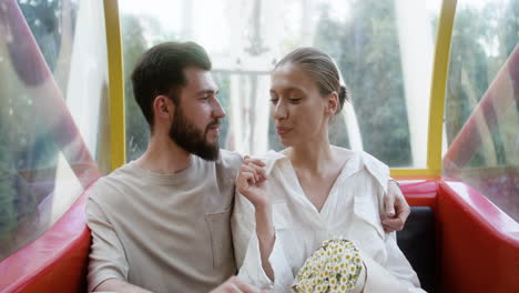 young couple eating popcorn on a ferris wheel