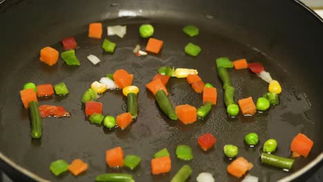 colorful vegetables arranged to spell 'food' in a pan