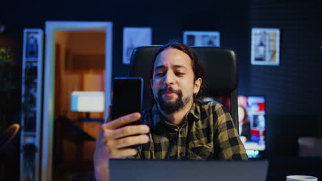 Man-talking-with-best-friend-during-video-conference-meeting-on-smartphone