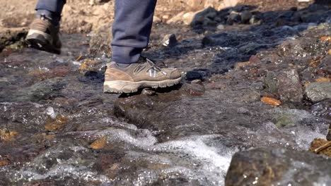 Hiker-crossing-a-small-stream-in-slow-motion