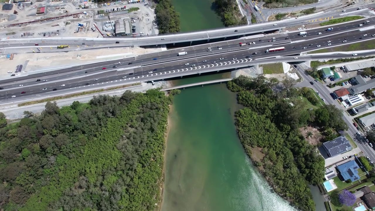Passarela do riacho Tallebudgera e Autoestrada do Pacífico atravessando o riacho Tallebudgera em Burleigh Heads, QLD, Austrália. Tomada aérea.