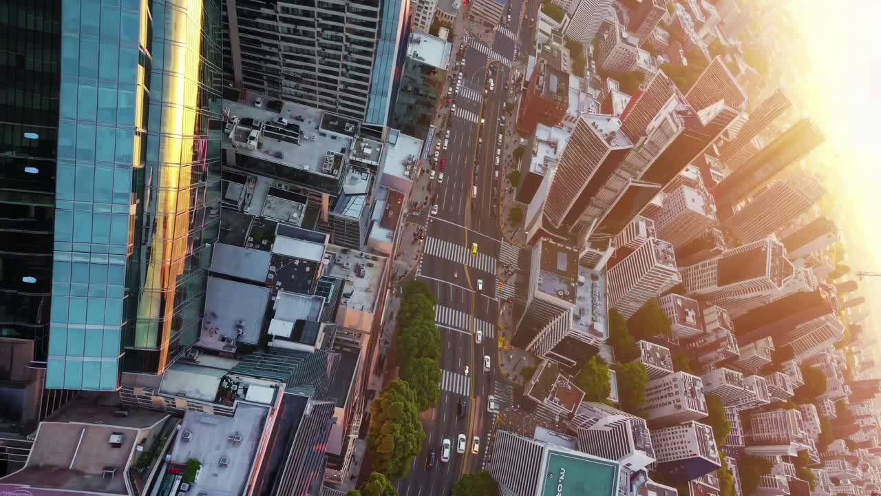 Dynamic aerial view of a bustling city street at sunset, showcasing urban life from a tilted angle