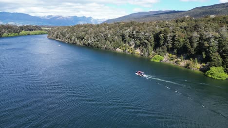 Three-boats-sailing-on-river-with-mountains-in-background