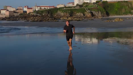 a lone man is running barefoot on the shore of praia de caión, spain. slow motion shot