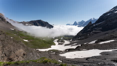 swiss alps valley with clouds and snow
