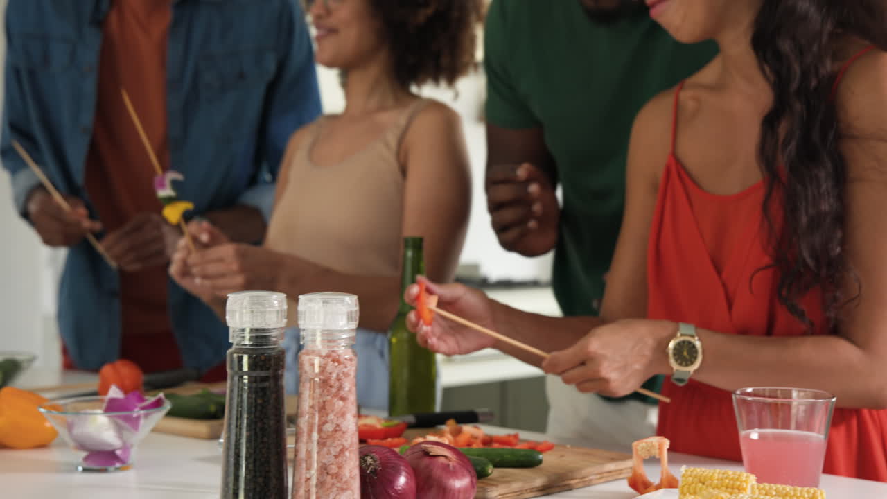 Cooking together in kitchen, diverse friends laughing and sharing culinary experience, at home