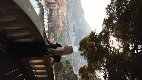 mujer hermosa en el balcón de la ciudad de mónaco vista al atardecer, vertical cinematográfico
