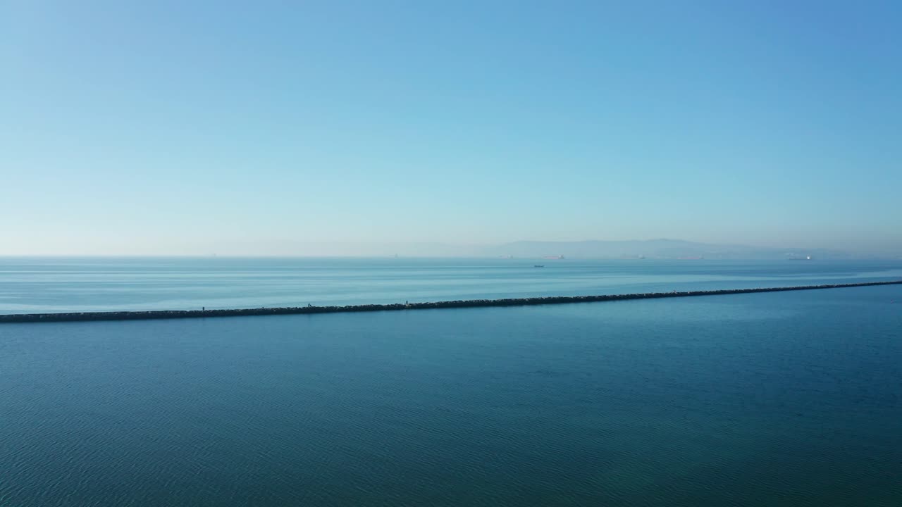 Incredible view of the breaker wall in the bay with blue skies and sunny day