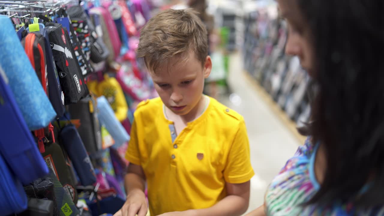 Back to school concept. Parents choosing school stationery in the supermarket