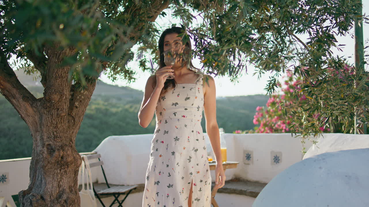 mujer de la siesta bebiendo agua en la terraza de la vista general. niña tierna bebiendo limonada
