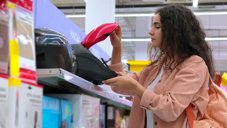 woman looking at a vacuum cleaner in a store