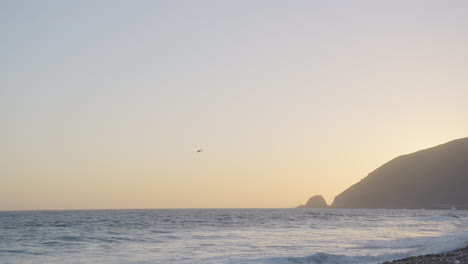 panning-ocean-shot-with-helicopter-in-the-distance