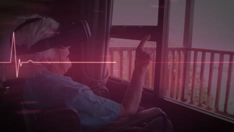 ⁇ 체어에 앉아 vr 헤드 ⁇ 을 착용한 백인 노인 여성에 대한 반 ⁇ 이는 빨간색 심박수 모니터