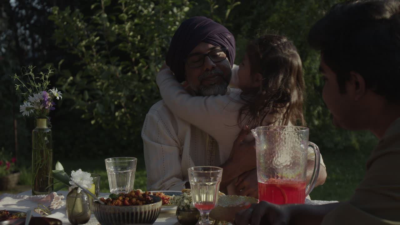 A Multi-Generational Family Sharing an Affectionate Outdoor Meal
