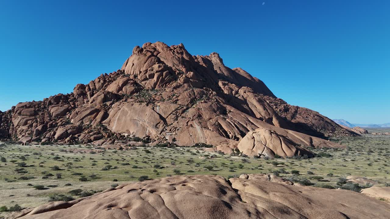 Aerial shot of Spitzkoppe’s granite domes in Namibia, revealing textures, desert trails, and untouched wilderness under bright African sunlight