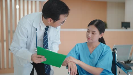 medical professional describes the condition of an asian woman on a wheelchair in hospital