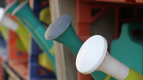 row of plastic colorful garden watering cans ready for school garden