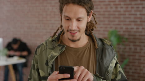 retrato joven estudiante de raza mixta usando un teléfono inteligente navegando chequeando mensajes disfrutando de una aplicación de búsqueda en línea en un café de internet peinado de rastas