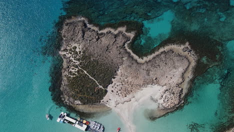 Top-view-rocky-outcrop-rises-from-turquoise-waters-of-Nissi-Beach,-Ayia-Napa-Cyprus