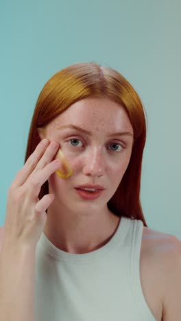 woman applying gold face mask