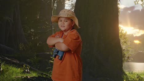 niño asiático con sombrero y binoculares cruzando los brazos y sonriendo a la cámara mientras explora la naturaleza del bosque. niño investigador examina algo, aventura de turismo de viaje, vista lateral