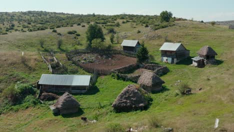 Huts-On-Meadow-Hills-With-Wooden-Cages-For-Livestock-Farming