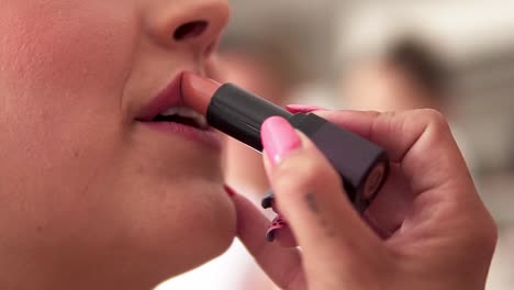 slow motion handheld close-zp shot of a bride being made up by a make up stylist for her wedding with her husband while lipstick is being applied