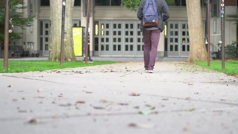 A-young-male-walks-across-a-college-campus-on-a-sunny-summer-day