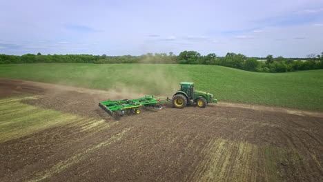 Agricultural-tractor-with-trailer-plowing-agricultural-field.-Rural-farming