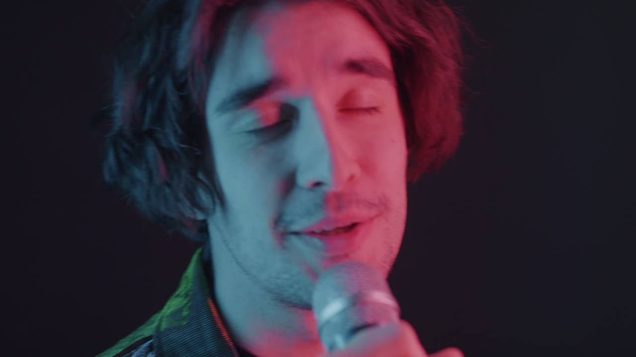 Man Singing into Microphone with Colorful Lights