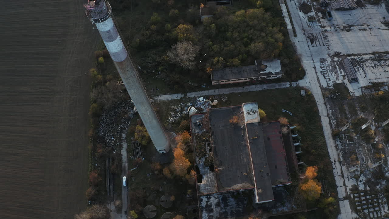 석양에 굴뚝이 있는 버려진 오래된 산업 공장의 넓은 공중 샷
